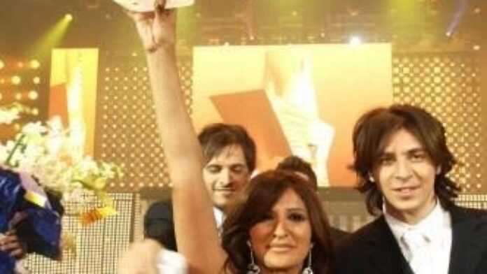 Shada Hassoon brandissant le trophée de la victoire.