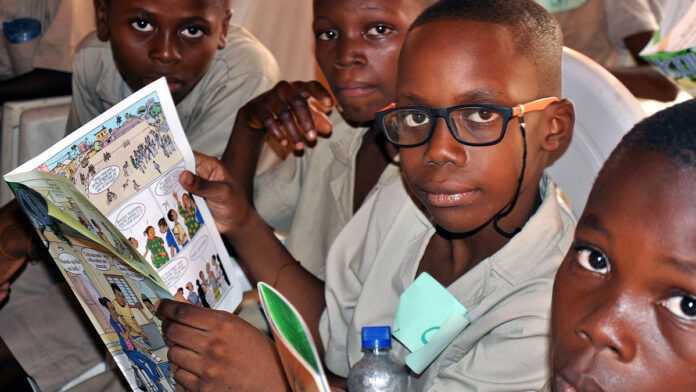 Des écoliers africains avec une bande dessinée