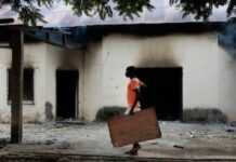 Un habitant devant un bâtiment incendié