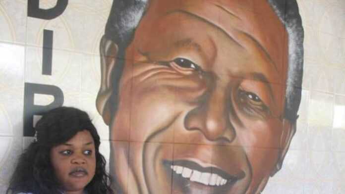 Fama Guèye, à côté de l'effigie de Madiba qui décore la structure