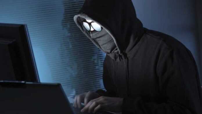 Une personne masquée sur ordinateur
