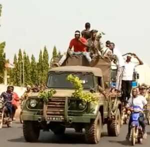 Manifestants sur un véhicule militaire au Bénin