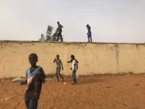 Des enfants sur le mur de clôture du Stade Lat Dior