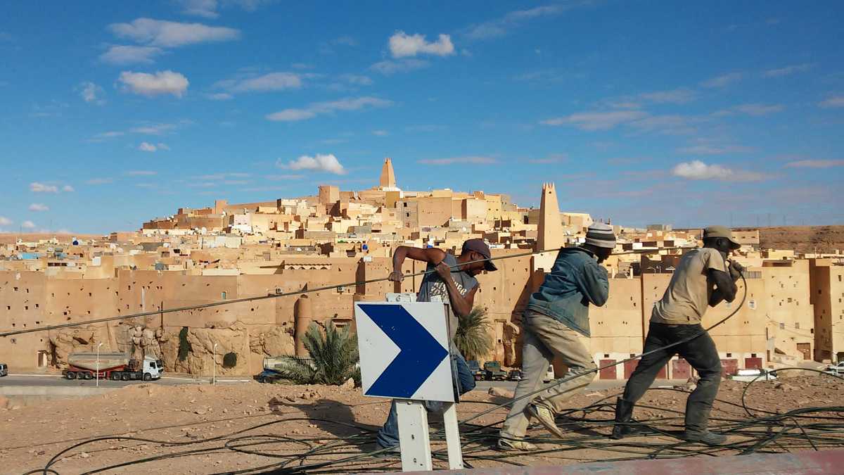 Trois hommes tirant un câble de téléphone