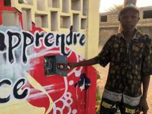 Victor Malick Ndione devant l'interrupteur du puits