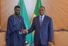 Poigne de mains entre Diomaye Faye et Macky Sall