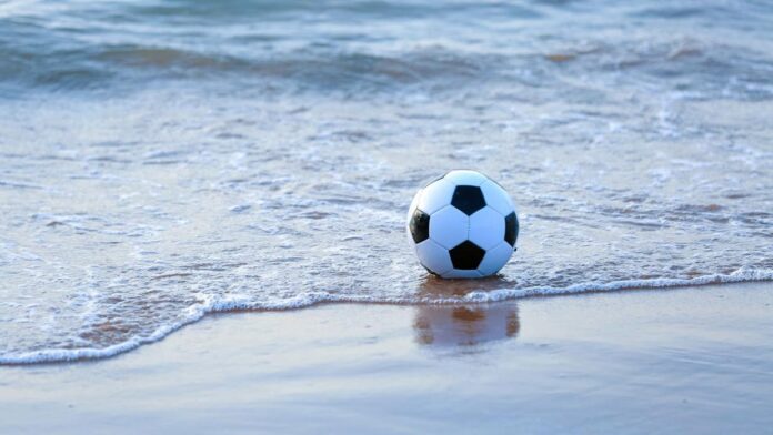 Un ballon de foot sur une plage