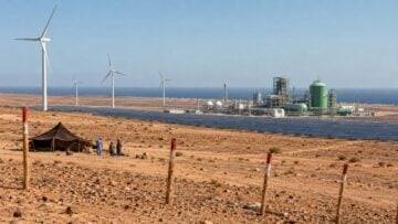 Sahara occidental : l’hydrogène vert relance les accusations d’exploitation contre le Maroc Paysage désertique côtier avec campement, panneaux solaires, éoliennes et installation industrielle, illustrant les projets d’hydrogène vert au Sahara occidental.