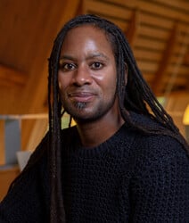 Jason Arday poses for a portrait in the Cambridge Faculty of Education library.